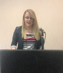 Rachel Lyn Atkins speaking at a podium. 